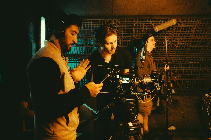 Film crew working with camera and microphones.